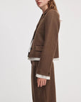 Rag & Bone Lawrence crop blazer in brown herringbone with three buttons, worn with a white shirt and matching trousers.
