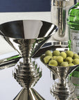Nickel L Condiment Bowl with olives and matching stemmed bowl on a mirrored tray by Bungalow Furniture & Accessories.