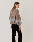 Maiami Fleecy Alpaca Intarsia Bomber Cardi in brown with a grey abstract hem motif worn by a woman.