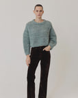 Fuzzy light blue Maiami Wool Alpaca Mix Cropped Pullover worn with dark brown trousers.