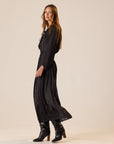 Bella Skirt by Natalie Martin in a vintage 70s style, paired with boots, styled against a beige backdrop.