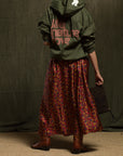 Free City LifeNatureLove RTU zip-up hoodie with floral skirt, brown boots, and dark clutch, shown from the back.