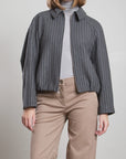 Pharaoh Andre Bomber Jacket in wool pinstripe, styled with a light gray turtleneck and beige pants.