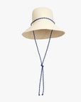 Natural straw rattan Romy hat with blue sail cord chin strap by Clare Vivier on white background.