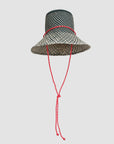 The Clare Vivier Romy Hat is a black and white woven straw rattan hat featuring a wide brim and a red sail cord strap tied in a knot, shown against a plain light background.