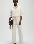 Cream high-waisted French terry sweatpants by Sold Out NYC, styled with dark glasses and burgundy bag.