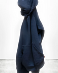 A navy blue BASIC GOODNESS HOODIE by Free City (sparrow, LLC), made in the USA, hangs on a hook against a plain white background. The text "freecity BASICgoodness" appears at the bottom of the image.