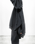 A dark gray unisex BASIC GOODNESS HOODIE by Free City (sparrow, LLC) in light French terry hangs on a hook against a plain white background with a concrete floor. “freecity BASICgoodness” is at the bottom, partially overlapping the image.