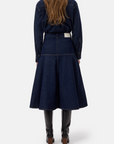 CLOSED dark blue denim midi zip skirt with an A-line flared hem, styled with black knee-high boots.