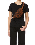 Jerome Dreyfuss Lino Banane brown leopard print bag worn crossbody with a chic black outfit.