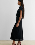 Rachel Comey Pout Dress in soft blush with maroon heeled sandals, styled in a modern, minimal interior setting.