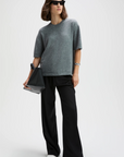 Gray cashmere oversized tee by Sold Out NYC styled with black wide-leg pants and white shoes, modern casual look.