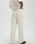 Cream Sold Out NYC sweatpant and top set, person standing hand on hip, modern casual style, neutral tone ensemble.