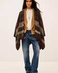 BA&SH Poncho Perros styled over casual jeans and jacket, modern neutral look against a plain backdrop.