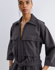 Charcoal grey gabardine Meet Jumpsuit by Bungalow with a front zipper, chest pockets, and a belted waist.