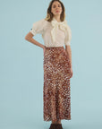 Hunter Bell NYC Suki Skirt in white, styled with a blouse, modeled against a light blue background.