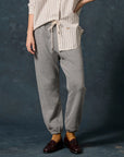 The Fleece Stadium Sweatpants in grey with drawstring waist, paired with a striped shirt, mustard socks, and loafers.