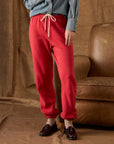 Bright red The Fleece Stadium Sweatpants with drawstring waist, styled with a denim shirt and dark loafers.