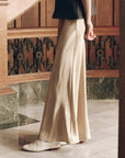 Elastic Bias Skirt in champagne metallic satin styled with a dark top and light shoes by Bungalow Furniture & Accessories.