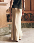 The Elastic Bias Skirt in metallic champagne satin paired with a dark t-shirt.