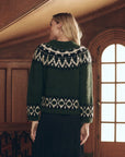 The Arctic Fairisle Pullover, a dark green alpaca knit sweater featuring a cream and black Fair Isle pattern.