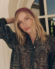 The Pleated Neck Tie blouse in a dark pattern with a matching headband from Bungalow Furniture & Accessories.