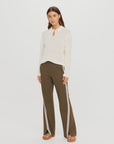 The Upside PETRA FLARE PANT with a white knit sweater, modern minimalist style against plain background.