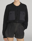 The Contrast Cashmere Cardi by FRAME paired with high-waisted leather shorts, styled in a modern, casual setting.