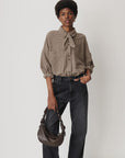 Sessun CECILY shirt in brown and black gingham with a knotted collar, styled with dark gray jeans and a shoulder bag.