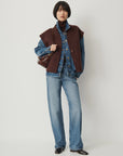 HELSPARK sleeveless jacket with shawl collar layered over a denim jacket, matching jeans, and a turtleneck.