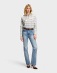 Plaid Sarah Alexandra, LLC Western shirt tucked into blue jeans with a brown leather belt and dark heels.