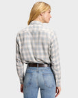 Light-colored plaid Western shirt tucked into blue jeans with a brown leather belt, styled for Bungalow.