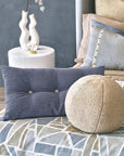 Navy tufted button pillow and cream Oliver Boucle spherical pillow on a geometric print duvet.