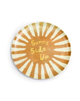 The Breakfast Club Plate Set by Sugarboo Designs features a round plate with yellow and white sunburst rays and "Sunny Side Up" in a playful font—ideal for your breakfast routine.