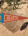The "Create" Felt Pennant by Faire features a vintage triangular design and is perfect as creative room decor or a thoughtful gift for inspiring creativity.