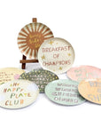 The Breakfast Club Plate Set by Sugarboo Designs features decorative plates with colorful designs and playful breakfast quotes, perfect for serving or adding a charming touch to your kitchen decor.
