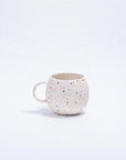 Round white stoneware Ball Mug with a colorful speckled pattern by Bungalow Furniture & Accessories.