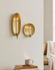 Brass wall candle sconces by Two Faire with lit candles create a cozy ambiance above a styled side table.