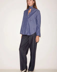 Roseanna Chemises Shirt with stand-up collar, pinstriped scarf, and dark wide-leg trousers.
