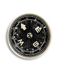 The Ben's Garden Dome Crystal Paperweight features a black and white compass with bold cardinal letters and an Earth illustration at the center, set on a white background—ideal as a unique handcrafted desk accessory.