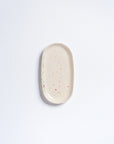 Small oval mini tray by Bungalow Furniture & Accessories in off-white stoneware with colorful confetti speckles.