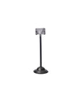 The Faire Desk Card Holder is a small, upcycled steel holder featuring a round, ridged base and a vertical rod with a rectangular clip on top, shown against a plain white background.