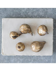 Set of five gold fig sculptures by Creative Co-op displayed on white paper atop a gray textured surface.
