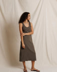 Olive ribbed midi tank dress by Perfectwhitetee, styled with sandals in front of a cream fabric backdrop.