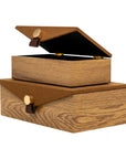 Stacked Harriett Box storage units by Bungalow Furniture & Accessories in wood grain with brown lids and leather pulls.