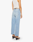 A person stands facing away, showcasing the back of Mother’s The Dodger Ankle high-waisted, ankle-length loose straight leg jeans, paired with a white sleeveless top and black wedge sandals.