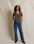 Gray boxy V-neck tee by Perfectwhitetee styled with blue jeans, shown in a neutral beige setting.