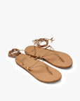 The Beek Koha Sandal features tan leather, molded arch support, thin ankle-wrap straps, and gold-tone hardware, shown against a plain white background.