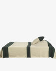 Libeco Home Omaha Stripe Coverlet in beige with dark green stripes, European flax linen, on a modern bed.