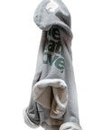 Gray Free City pullover hoodie with green text and white lining, draped on a hook.